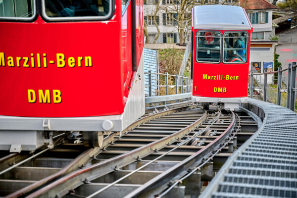 Nahaufnahme zweier roter Wagen der Marzilibahn in Bern. Die wagen kreuzen sich auf halber Strecke.